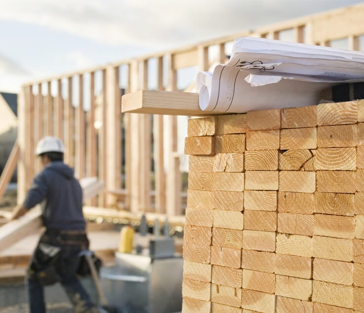 Worker building a house with lumber