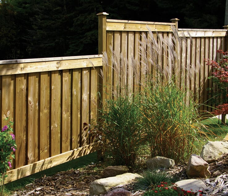 beautiful multi-tiered wooden fence behind a garden